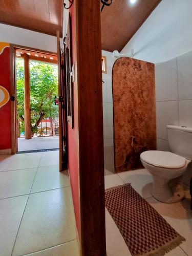 a bathroom with a toilet and a shower and a door at Hostel-Agência Chapada Backpackers in Lençóis