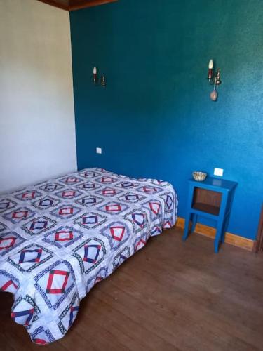 une chambre avec un lit et un mur bleu dans l'établissement Maison avec magnifique vue, Gorges du Tarn et Jonte, à Peyreleau