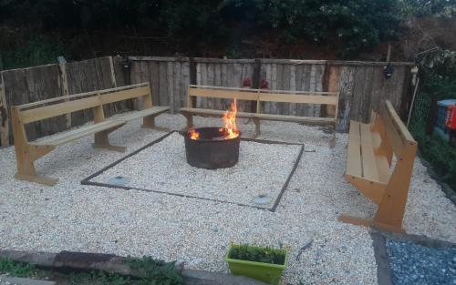 un foyer extérieur dans une arrière-cour avec deux bancs dans l'établissement Pepe's Naturist Pod for 2 people Pays de la Loire, à Colombiers-du-Plessis