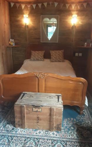 un lit en bois avec un coffre dans une pièce dans l'établissement Pod - Sleeps 2 - Jacuzzi - Parking - Garden, à Colombiers-du-Plessis