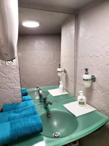 une salle de bain avec un lavabo vert et un miroir dans l'établissement Appart COSY 2 ch Caluire et Cuire Lyon, à Caluire-et-Cuire