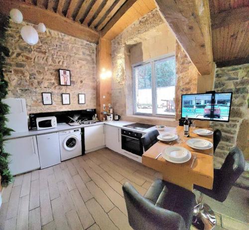 une cuisine avec une table et des chaises dans une pièce dans l'établissement Appart COSY 2 ch Caluire et Cuire Lyon, à Caluire-et-Cuire