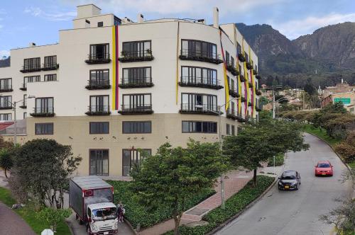 un edificio alto con coches estacionados frente a él en R6/ Amplió loft en la Candelaria, en Bogotá