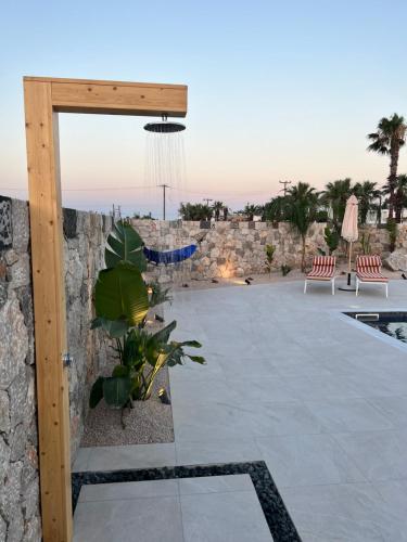 uma vista para um pátio com uma parede de pedra em Cora May Central Villa with private pool 200m to the beach em Faliraki