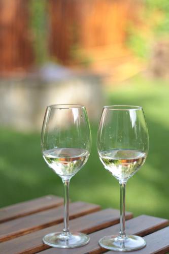 dos vasos de vino blanco sentados en una mesa en Mi szél hozott, en Lipót