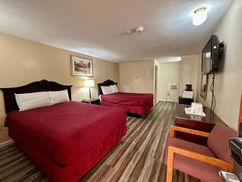 Cette chambre comprend deux lits et une télévision. dans l'établissement Red Carpet Inn Pulaski, à Pulaski
