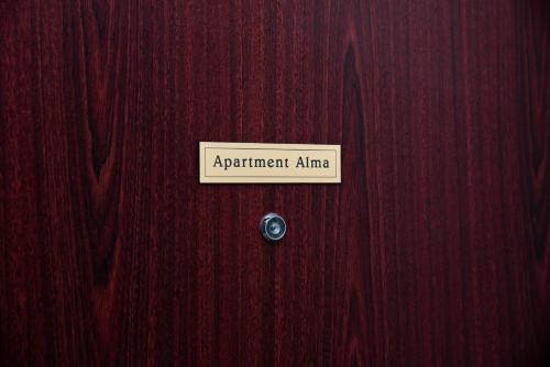 a sign on a wooden door that says a participant amnesia at Alma apartments in Mostar