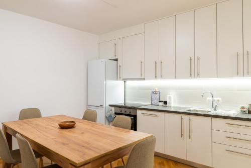 a kitchen with a wooden table and white cabinets at Alma apartments in Mostar