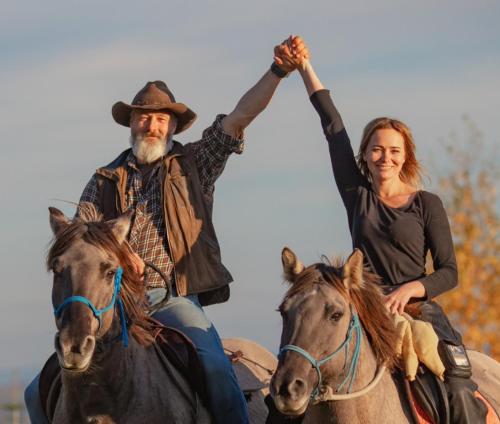 a man and woman riding on horses with their hands in the air at Chata z Widokiem in Międzybrodzie Bialskie