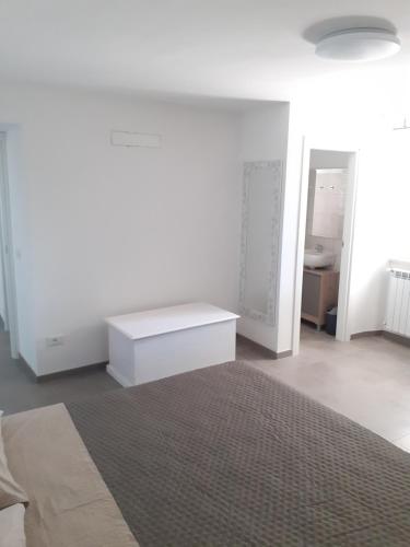 a white room with a bed and a table at Residence LE DUNE in Ortona