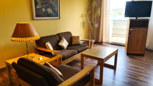 ein Wohnzimmer mit einem Sofa und einem Tisch in der Unterkunft City Hotel Pforzheim in Pforzheim
