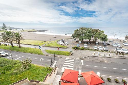 a view of a street and a beach with cars at Casa Mar 4 in Ponta Delgada