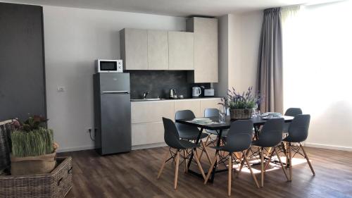 a kitchen with a table and chairs and a refrigerator at Corte Francigena in Montalcino