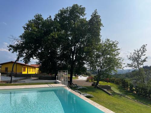 ein Pool im Garten mit einem Baum in der Unterkunft Colle Del Sole in Lastra a Signa