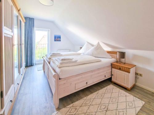 a bedroom with a large bed and a window at Küstenschwalbe in Greetsiel