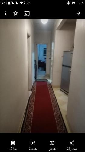 pasillo con alfombra roja en una habitación en Gibran residence, en Kafr al Ishārah