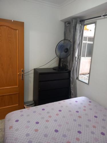 a bedroom with a bed and a dresser and a window at habitación pequeña en piso compartido con 2 adultos y 1 perrito in Valencia