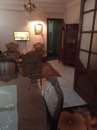 a living room with chairs and a table and a chandelier at Gibran residence in Kafr al Ishārah