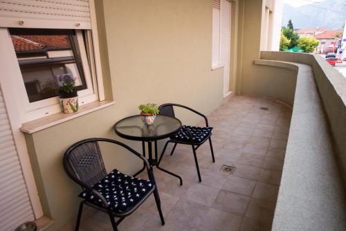 a balcony with a table and two chairs and a window at Alma apartments in Mostar