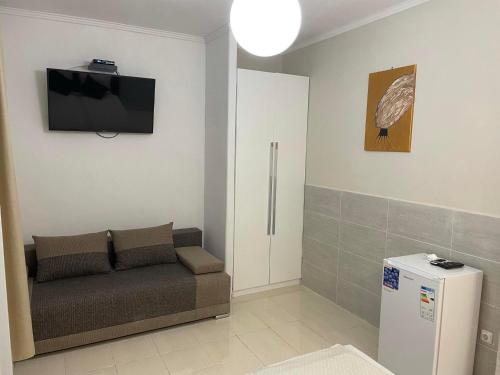 sala de estar con sofá y TV en la pared en Adam Apartman, en Hajdúszoboszló