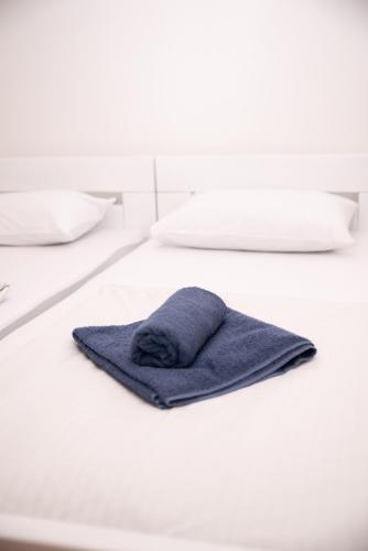 a blue towel is sitting on a white bed at Alma apartments in Mostar