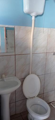 a bathroom with a toilet and a sink at Pousada MG in Foz do Iguaçu
