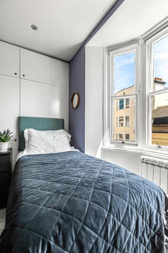 a bedroom with a large bed and two windows at Brighton Lanes by Airhost in Brighton & Hove