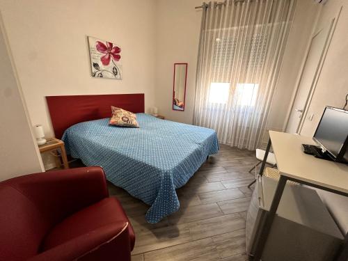 um pequeno quarto com uma cama e uma cadeira em B&B Dafne Marsala Centro em Marsala