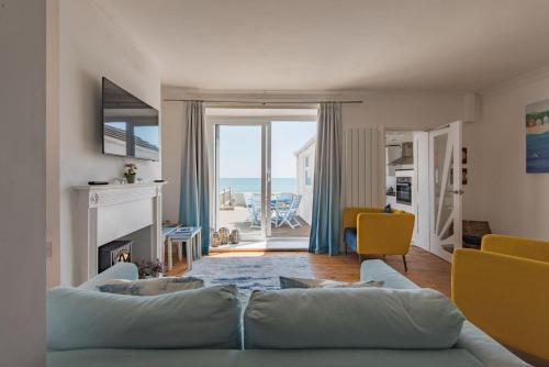 a living room with a couch and a view of the ocean at Wave Cottage by Bloom Stays in Sandgate