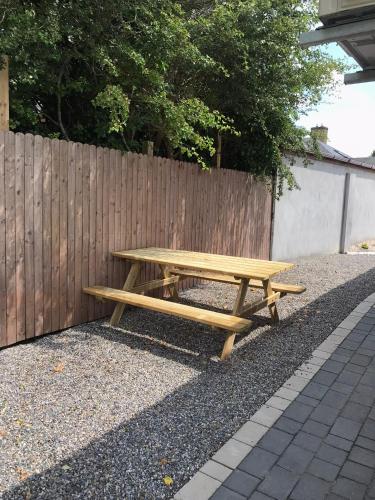 a wooden picnic table sitting next to a fence at Ard na Gréine in Stradbally