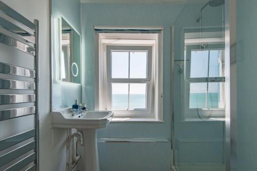 a bathroom with a sink and a window and a shower at Wave Cottage by Bloom Stays in Sandgate