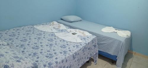 a bed with shoes on top of it in a room at Pousada MG in Foz do Iguaçu