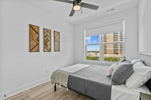 a white bedroom with a bed and a window at 10 Ocean A Powered By Atkinson Realty in Virginia Beach