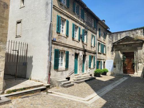 um edifício antigo com persianas verdes numa rua em Au Centre de Villeneuve-lès-Avignon em Villeneuve-lès-Avignon