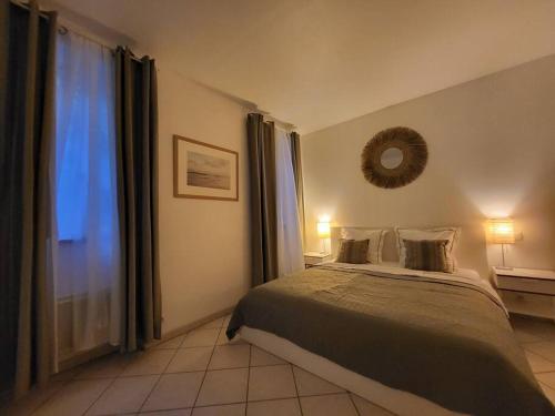 um quarto com uma cama e um espelho na parede em Au Centre de Villeneuve-lès-Avignon em Villeneuve-lès-Avignon