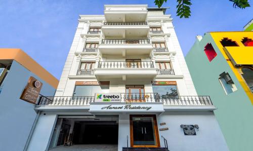 a tall white building with a sign on it at Treebo Aaravi Residency, 800 Mtrs From Promenade Beach in Puducherry