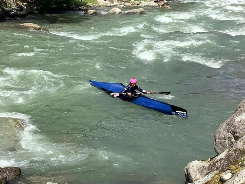a person in a blue kayak in a river at Maison Eglantine in Mezzana