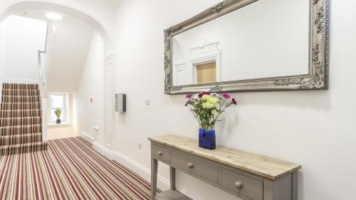 wazon kwiatów na komodzie w korytarzu w obiekcie 1 Bed Ranelagh By Pureserviced w mieście Plymouth