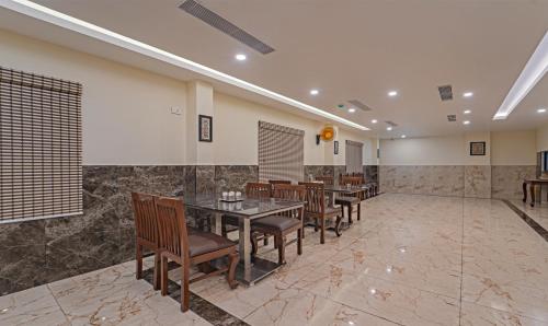 a dining room with chairs and a table in a room at Treebo Aaravi Residency, 800 Mtrs From Promenade Beach in Puducherry