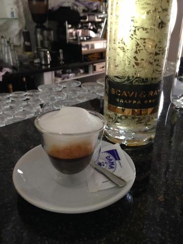 a cup of coffee on a plate next to a bottle at Hotel Haus Hubertus in Schneverdingen