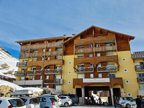 a large building with cars parked in front of it at Appartement 1 chambre, calme, vue dégagée, La Foux in La Foux