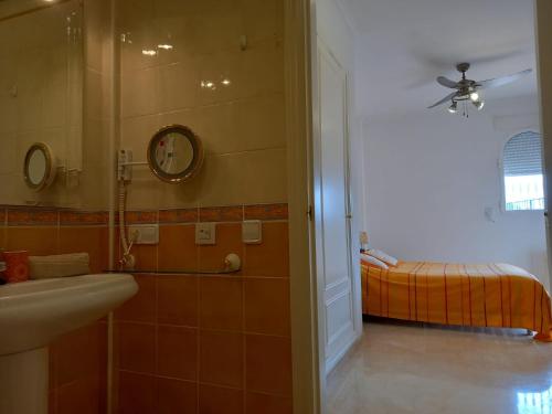 a bathroom with a sink and a shower with a bed at Villa Suiza in Altea