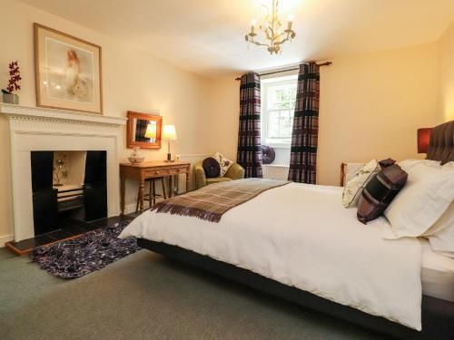 a bedroom with a bed and a fireplace at Tennant Cottage in Malham