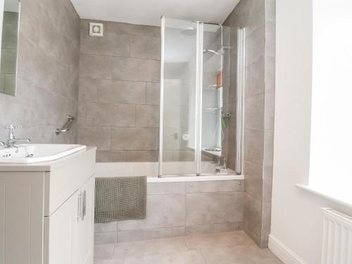 a bathroom with a shower and a sink at Tennant Cottage in Malham