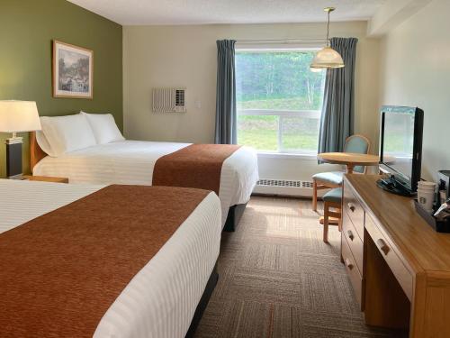 a hotel room with two beds and a television at Coast Hinton Hotel in Hinton