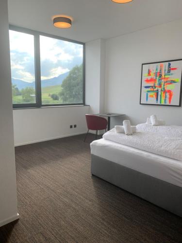 a hotel room with two beds and a large window at Laurin‘s in Schaanwald
