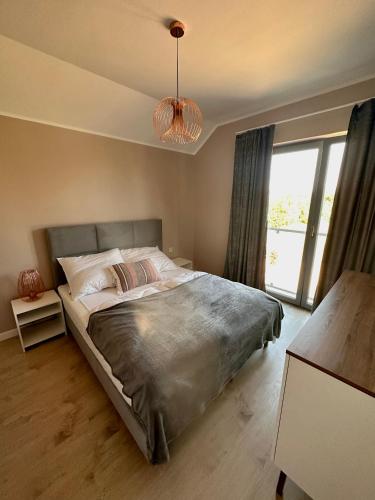 a bedroom with a bed and a large window at Domy wakacyjne WELLE in Kołczewo