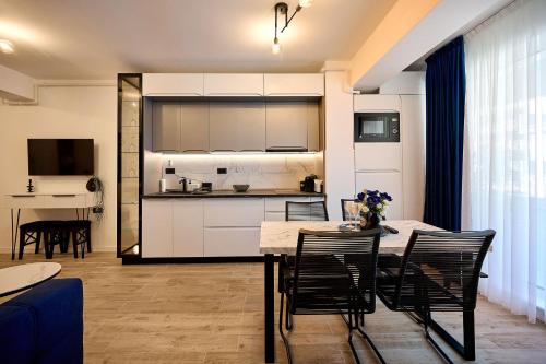 a kitchen and living room with a table and chairs at Infinity by Sea Apartment Beach Resort - parking in Mamaia