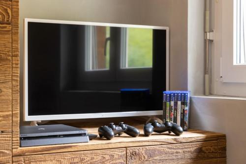 a flat screen tv sitting on top of a entertainment center at Lucky Fox in Leukerbad