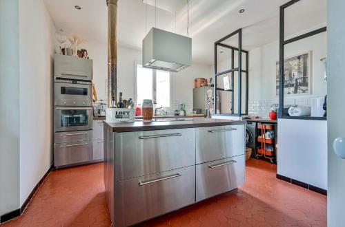 une grande cuisine avec des armoires et des appareils en acier inoxydable dans l'établissement Haut de Villa à 300m des plages, à La Ciotat